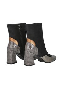 Botas de tobillo de ante negro con un tacón de bloque de color gris con patrón de cocodrilo y acentos metálicos en bronce, que presentan un cierre con cremallera lateral.
