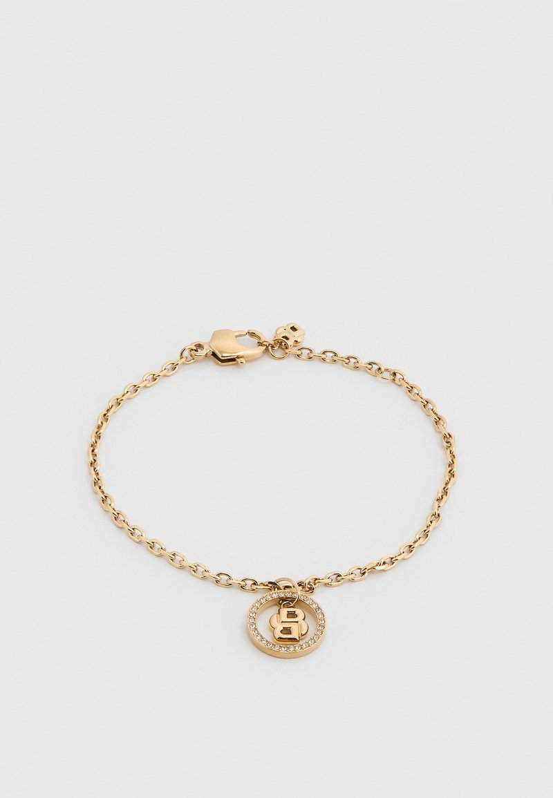 Βραχιόλι με αλυσίδα από χρυσό με κυκλικό μοτίβο που διαθέτει περίγραμμα από στρας και μια ανάγλυφη επιστολή "B" στο κέντρο, ασφαλισμένο με κούμπωμα τύπου καβουριού.