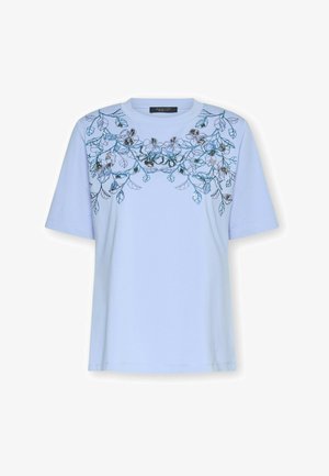 Hellblaues T-Shirt mit kurzen Ärmeln, das eine Blumenstickerei in Dunkelblau, Grün und Schwarz zeigt, mit rundem Ausschnitt und lockerem Schnitt.