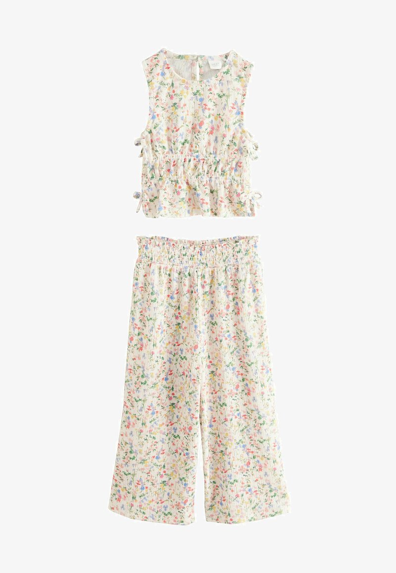 Blomster to-delt sæt med en ærmeløs top med samlede detaljer og matchende vide bukser. Let stof med en pastel farvepalette.