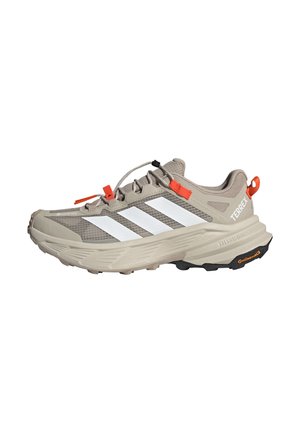 Scarpa da trail running Adidas Terrex beige chiaro con strisce bianche, linguetta arancione e suola texturizzata con logo Continental.