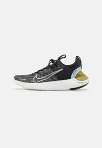 Nike Free sportcipők fekete kötött felsőrésszel, textúrált mintával, sárga díszítéssel és fehér talppal. Felszerelt fűzőkkel és logóval a sarkon.