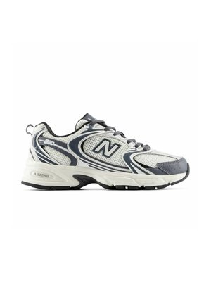 Witte en grijze New Balance hardloopschoen met zwarte veters, mesh bovenwerk, gedempte zool en "ABZORB" label op de hiel tussenzool.