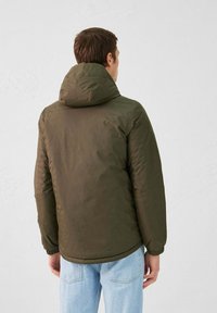Doudoune vert olive avec capuche, dotée de poignets élastiques et d'un ourlet légèrement arrondi. Extérieur lisse avec une finition mate.