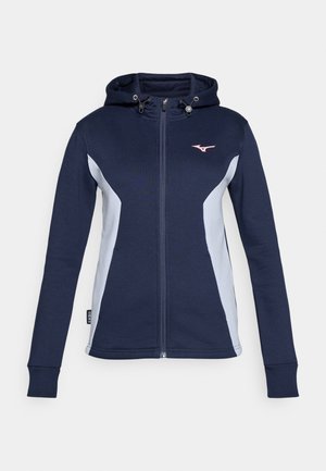 Marineblå zip-up hettegenser med lysegrå sidestykker, snorhette og rosa logo på brystet. Myk stoff med tettsittende ermer og hem.