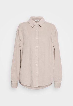 Beige corduroy overhemd met een knoopsluiting aan de voorkant, lange mouwen en een kraag. Verticale ribbelstructuur en een afgeronde zoom.