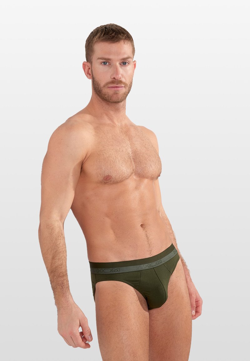 Donkergroene katoenen slip met een contrasterende grijze tailleband met de merknaam. Glad materiaal, aansluitend ontwerp en minimale bedekking.