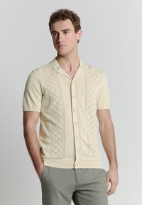 Lichtgele cardigan met korte mouwen, voorzien van een gestructureerd ruitpatroon, knoopsluiting en platte kraag, gemaakt van gebreide stof.