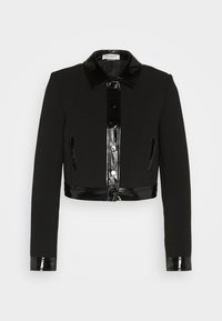 Veste courte noire à manches longues, col en cuir verni brillant, patte de boutonnage, poignets, ourlet et poches latérales.
