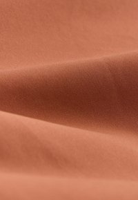 Tampo textile de culoare teracotă caldă, textură netedă, suprafață ușor lucioasă, cu o extensibilitate subtilă și fără modele sau accente vizibile.