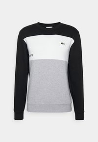 Sweat-shirt à col rond en bloc de couleurs noir, blanc et gris. Comprend des poignets élastiques, un logo sur la poitrine et une texture douce.