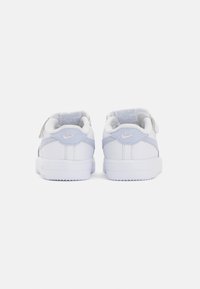 Beli Nike čevlji z svetlo modrimi detajli, usnjena površina, nizka zasnova, okrogla konica in teksturiran gumijast podplat.