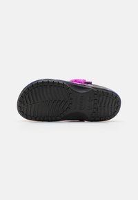 Zwarte rubberen loopzool met een gestructureerd grippatroon, voorzien van een paarse en roze decoratieve band, ontworpen voor comfort en casual gebruik.