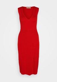 Robe rouge sans manches avec un col en V, une texture côtelée ajustée et un ourlet arrivant au genou. Comprend une fente latérale pour plus de détail.