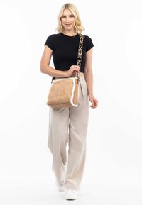 Borsa a tracolla in suede marrone con rifiniture in pelliccia bianca, tracolla con motivo e forma rettangolare. Presenta una chiusura a pattina e un marchio sottile.