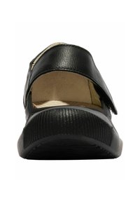 Zapato de cuero negro con un diseño de apertura amplia, suela de goma texturizada y costuras visibles en la parte superior. El interior muestra un forro de color claro.