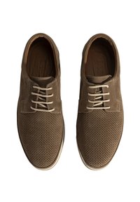 Chaussures en cuir perforé marron avec des lacets beige, bout rond et semelle blanche. Texture lisse avec de subtils accents de couture.