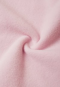 Miękka, lekka różowa polarowa tkanina o gładkiej teksturze, z delikatnym wzorem wiru i jednolitą barwą na całej powierzchni.