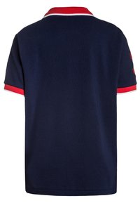 Marinblå polo t-shirt med röd och vit randig krage och ärmkanter. Har korta ärmar och ett slätt, texturerat tyg.