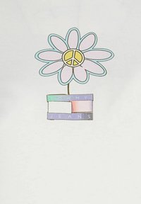 Camiseta blanca con un gráfico floral que presenta una flor rosa, un símbolo de paz amarillo en el centro y "TOMMY JEANS" en coloridas letras en bloque.