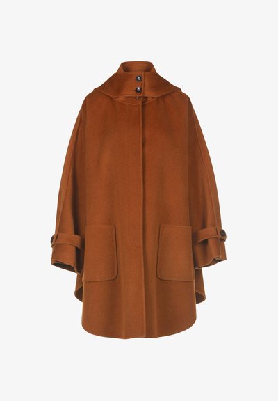 Cappotto di lana marrone con colletto alto, grandi tasche frontali e maniche arrotolate, caratterizzato da dettagli con bottoni e un design ampio simile a una cappa.