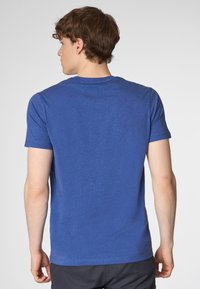 T-shirt blu heather, maniche corte, scollatura rotonda, texture morbida, vestibilità rilassata, etichetta visibile all'interno del colletto.