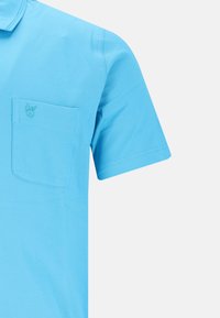Kurzärmliges Poloshirt aus leuchtend blauem Baumwollmaterial mit einer Brusttasche und gesticktem Logo. Glatte Textur, klassischer Kragen und gesteppte Details.