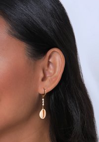 Guldøreringe med hængende skaller og perleaccentuer. Skallen er cremet med en brun stribe; perlerne er små og runde.