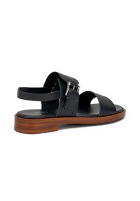 Sandal in pelle nera con due fasce larghe, cinturino alla caviglia regolabile, dettaglio con fibbia in argento e tacco basso in legno. Finitura liscia.
