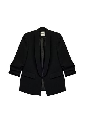 Blazer negro a medida con solapa de satén tipo chal, mangas largas con ligeros frunces, dos bolsillos frontales con solapa y diseño de apertura delantera.