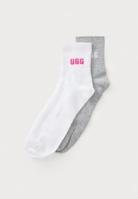 Zwei Paar Crew-Socken: ein weißes Paar mit pinkem UGG-Logo und ein graues Paar mit grauem UGG-Logo, beide mit gerippten Bündchen und weichem Material.