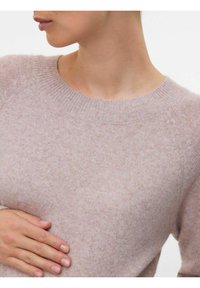 Ljusrosa stickad tröja med ribbad rund halsringning och raglanärmar, tillverkad av ett mjukt strukturerat tyg.