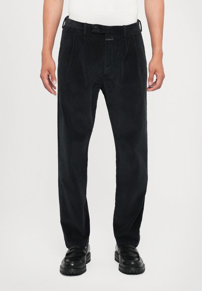 Pantalones de pana negros con corte recto, que presentan pliegues en la parte delantera, un cierre de botón y trabillas para cinturón; tejido suave y texturizado.