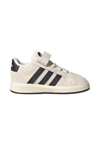 Light beige suede sneakers with three black stripes, a velcro strap, and a textured rubber sole, featuring a rounded toe and cushioned collar.