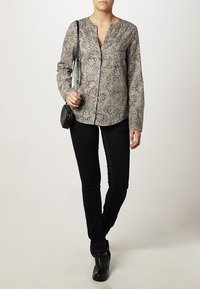 Langærmet, knap-op skjorte i et let stof med et blomstermønster i grå og sort. Sættes sammen med mørke slim-fit bukser og ankelstøvler.