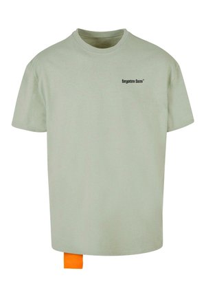 Gaiši zaļa kokvilnas t-krekls ar apkakli un īsām piedurknēm. Uz priekša ir neliels melns logo un apakšā ir oranža birka.