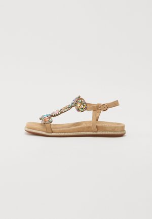 Braune flache Sandalen mit einer Wildleder-Textur. Verfügt über dekorative Steine in rosa, blau und grün. Schnallenverschluss und glitzernde Sohle.