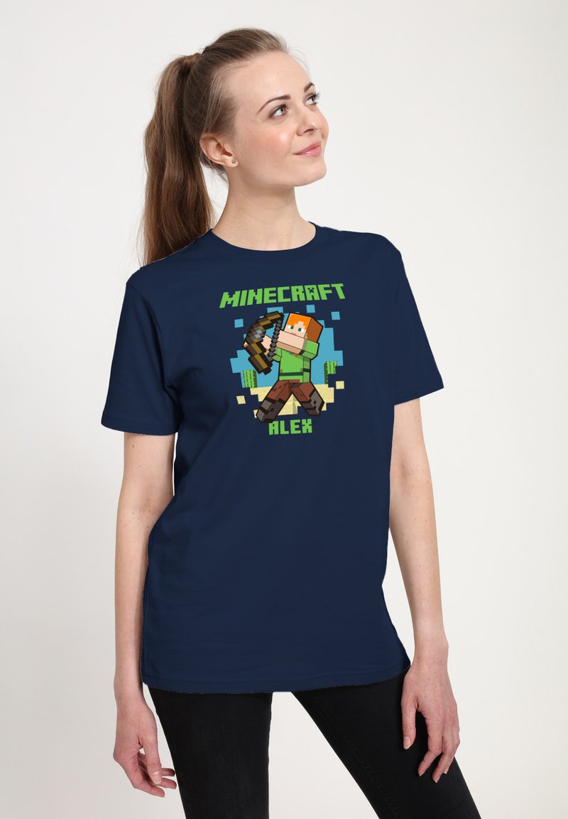 Námorně modré tričko se zobrazenou pixelovanou postavou z Minecraftu jménem Alex, která drží luk. Grafika obsahuje živé barvy a silný text.