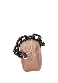 Beige leren tas met een gestructureerde afwerking, voorzien van een zwarte chunky kettinghandgreep, dubbele ritsluiting en metalen accenten.