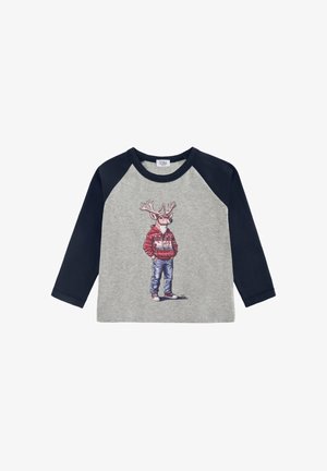 Maglietta grigia a maniche lunghe con maniche raglan blu navy, con una grafica di un cervo in un maglione rosso e jeans, su uno sfondo semplice.