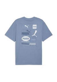 Tricou din bumbac de culoare albastru deschis, cu diverse logo-uri și grafice Puma în nuanțe mai închise de albastru. Croială lejeră, cu mâneci scurte și decolteu rotund.