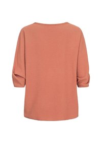 Roze blouse met driekwartmouwen en een relaxte pasvorm. Gestructureerde stof en een ronde halslijn. Eenvoudig, onopgesmukt ontwerp.
