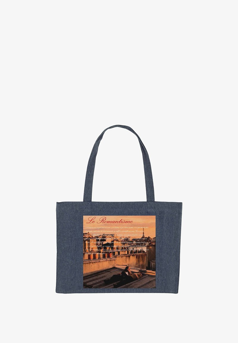 Sac fourre-tout bleu marine avec une photo imprimée de deux personnes allongées sur un toit au coucher du soleil, avec des cheminées parisiennes en arrière-plan.