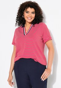 Polo à manches courtes rayé rouge et blanc avec un col en V et des accents de col bleu marine, fabriqué en tissu doux et léger.