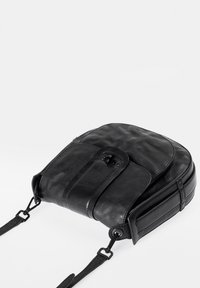 Schwarzer Leder-Rucksack mit runder Form, glatter Textur, Vorderklappe und verstellbaren Schulterriemen. Verfügt über einen Knopfverschluss und minimale Verzierungen.