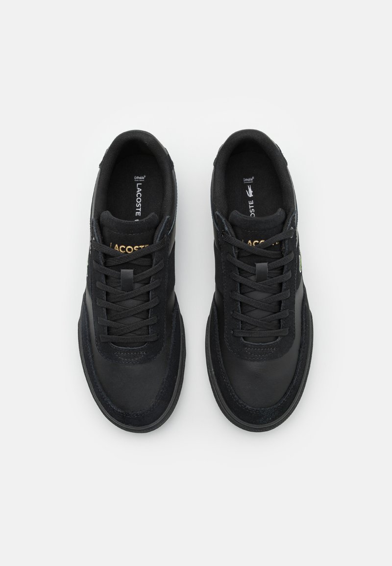 Czarne sneakersy z gładkiej skóry i tekstylnego wierzchu, zawiązywane, z okrągłym noskiem. Posiadają złote logo i teksturowane akcenty.