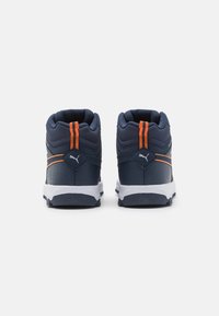 Marineblaue Sneaker mit orangefarbenen Akzenten, strukturiertes Synthetik-Obermaterial, gepolsterter Schaft und weiße Gummisohle mit auffälligem Profil.