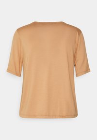 Blusa bege de manga curta com decote redondo, textura suave e bainha reta. Design simples, sem padrões ou embelezamentos.