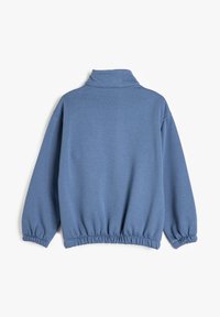 Pullover azul de manga larga con cuello alto, cintura y puños elásticos. Presenta una textura suave y un ajuste relajado y holgado.