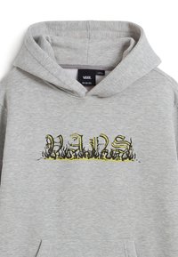 Světle šedá mikina s kapucí s visačkou Vans uvnitř límce a textovým designem "VANS" na přední straně obklopeným černými a žlutými plamenovými grafikami.